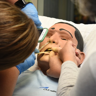 A student nurse working with a simulation mannequin.